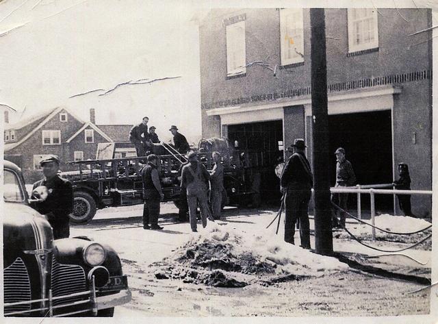 Packing hose in front of the original firehouse - Circa late 1930's